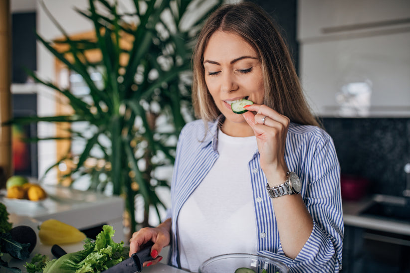 Woman eating cucumbers out of a bowl