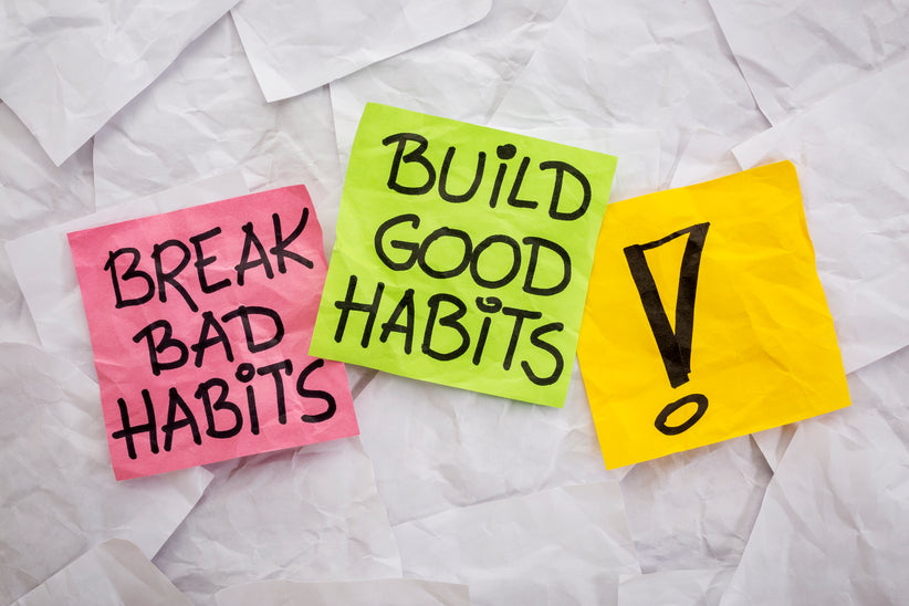 Two sticky notes. One says break bad habits and the other says build good habits